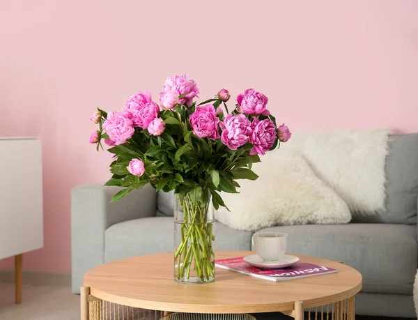 客厅里有沙发的咖啡桌上的粉色牡丹 — 图库照片