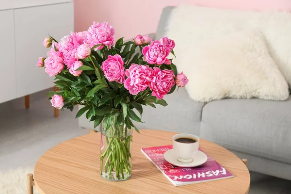 リビングルームでソファとコーヒーテーブルの上のピンクの牡丹の花瓶 — ストック写真