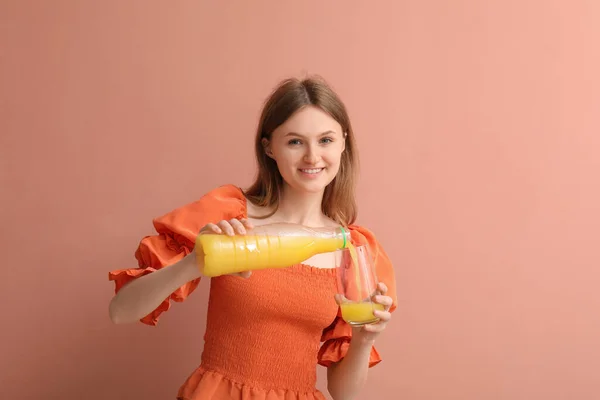 Tiener Meisje Gieten Sinaasappelsap Glas Roze Achtergrond — Stockfoto