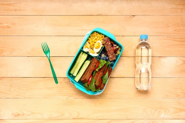 Fles Water Vork Lunchbox Met Lekker Eten Bruine Houten Ondergrond — Stockfoto