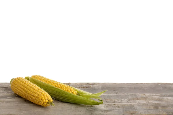 白色背景下灰色木制桌子上的新鲜玉米芯 — 图库照片