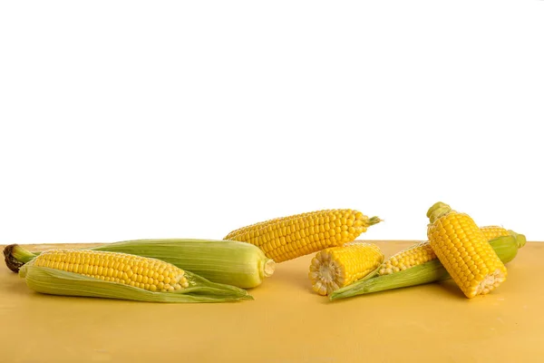Friss Kukorica Cobs Sárga Asztal Fehér Háttér — Stock Fotó
