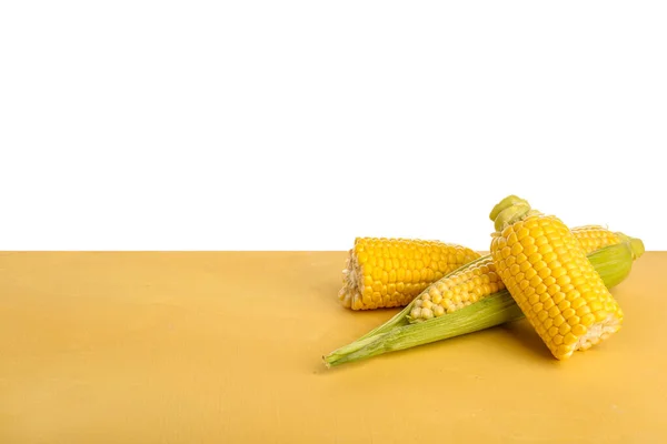 Verse Maïskolven Gele Tafel Tegen Witte Achtergrond — Stockfoto