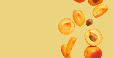 Renk arkaplanı üzerinde taze kayısılar ve metin için boşluk uçuyor