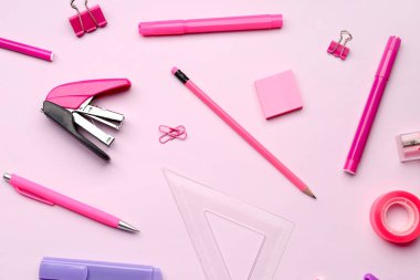 Pembe arka planda kırtasiye malzemeleriyle kompozisyon