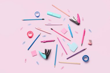 Pembe arka planda kırtasiye malzemeleriyle kompozisyon