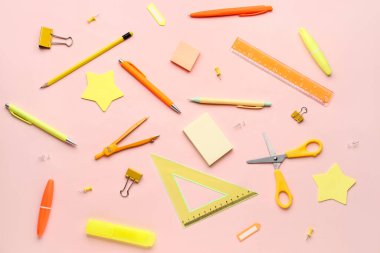 Pembe arka planda kırtasiye malzemeleriyle kompozisyon