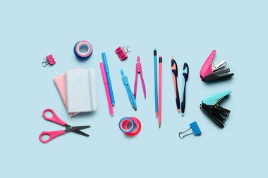 Mavi arkaplanda kırtasiye malzemeleri ile kompozisyon