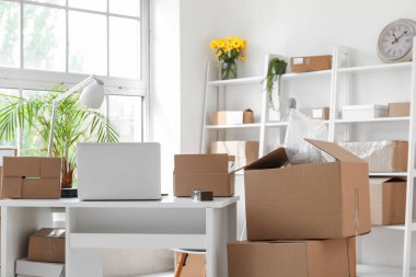 Ofiste dizüstü bilgisayarı ve paketleri olan bir işyeri