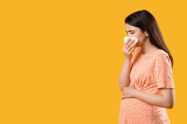 Hasta hamile kadın sarı arka planda