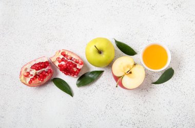 Olgun elmalar, nar, bitki yaprakları ve arkaplanda bal içeren kompozisyon. Rosh hashanah (Yahudi Yeni Yılı) kutlaması