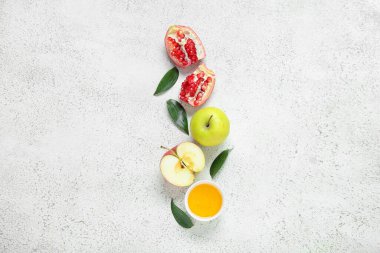 Olgun elmalar, nar, bitki yaprakları ve arkaplanda bal içeren kompozisyon. Rosh hashanah (Yahudi Yeni Yılı) kutlaması