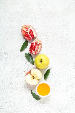 Olgun elmalar, nar, bitki yaprakları ve arkaplanda bal içeren kompozisyon. Rosh hashanah (Yahudi Yeni Yılı) kutlaması