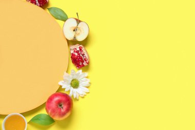 İçinde boş kart, taze meyve, bal ve sarı arka planda çiçekler olan kompozisyon. Rosh hashanah (Yahudi Yeni Yılı) kutlaması