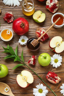 Ahşap zemin üzerinde taze meyve, çiçek ve bal içeren kompozisyon. Rosh hashanah (Yahudi Yeni Yılı) kutlaması