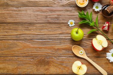 Ahşap zemin üzerinde taze meyve, çiçek ve bal içeren kompozisyon. Rosh hashanah (Yahudi Yeni Yılı) kutlaması