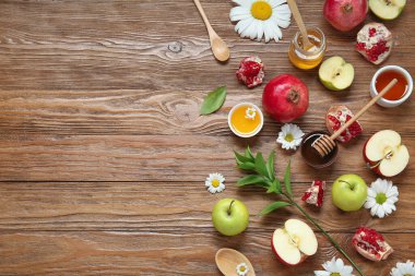 Ahşap zemin üzerinde taze meyve, çiçek ve bal içeren kompozisyon. Rosh hashanah (Yahudi Yeni Yılı) kutlaması