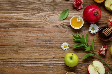 Ahşap zemin üzerinde taze meyve, çiçek ve bal içeren kompozisyon. Rosh hashanah (Yahudi Yeni Yılı) kutlaması