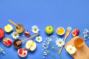 Renkli arka planda güzel çiçekli, meyveli ve ballı kompozisyon. Rosh hashanah (Yahudi Yeni Yılı) kutlaması