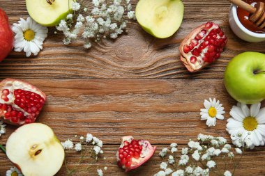 Ahşap arka planda taze meyve ve çiçeklerden yapılmış çerçeve, yakın plan. Rosh hashanah (Yahudi Yeni Yılı) kutlaması