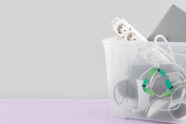 Renkli arka planda farklı ev aletleri olan geri dönüşüm kutusu