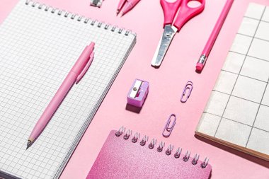 Pembe arka planda farklı okul kırtasiyeleri, yakın plan.