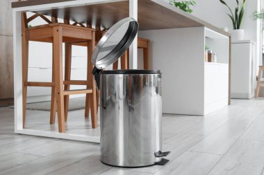 Mutfağın içindeki çöp kutusunu açtı.