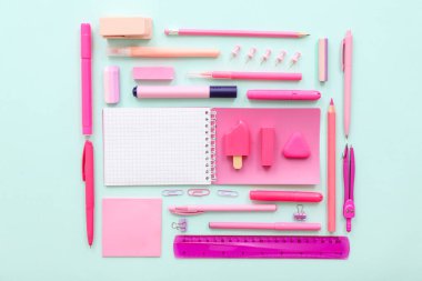 Mavi arkaplanda farklı kırtasiye malzemesi olan boş bir defter