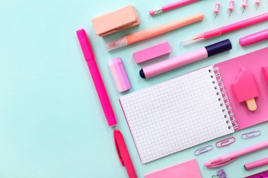 Mavi arkaplanda farklı kırtasiye malzemesi olan boş bir defter