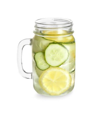 Beyaz arka planda salatalıklı Mason kavanozu.