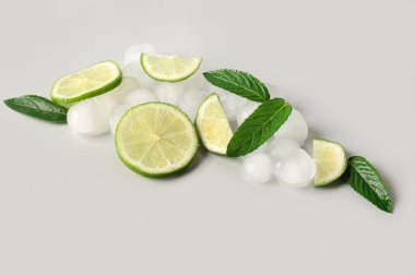 Buzlu limon dilimleri ve gri arkaplanda nane şekeri.
