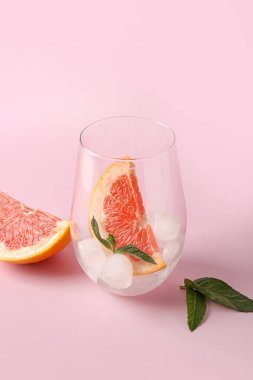 Buzlu bardak, greyfurt ve pembe arkaplanda nane.