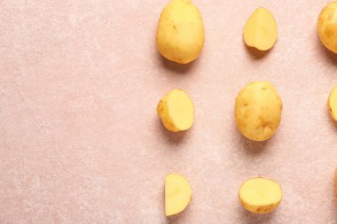 Çiğ patates ve pembe arka planda dilimler.