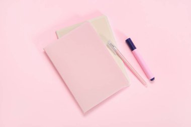 Pembe arkaplanda kalem ve işaret olan defter