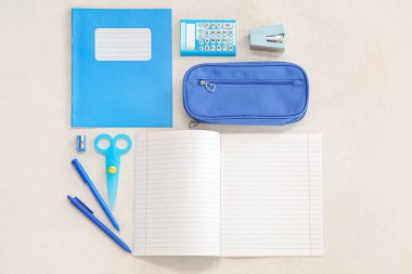 Beyaz arkaplanda farklı kırtasiye malzemesi olan defterler