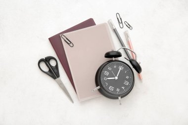 Alarm saati beyaz arkaplanda farklı kırtasiye malzemesi