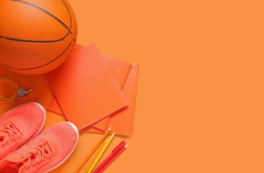 Toplu spor ayakkabıları, ıslık ve turuncu arka planda farklı kırtasiye malzemeleri.