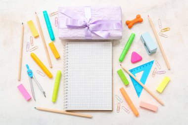 Beyaz zemin üzerinde farklı kırtasiye malzemesi olan hediye kutusu