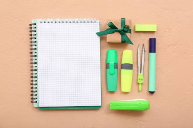 Turuncu zemin üzerinde farklı kırtasiye malzemesi olan hediye kutusu