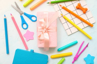 Beyaz zemin üzerinde farklı kırtasiye malzemesi olan hediye kutusu
