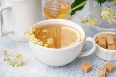 Beyaz arka planda limonlu ıhlamur çayı.