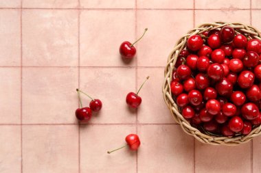 Arka planda pembe kirazlı hasır kase.