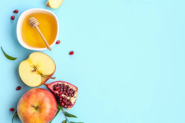 Renkli arka planda bir kase ballı meyve kompozisyonu. Rosh hashanah (Yahudi Yeni Yılı) kutlaması