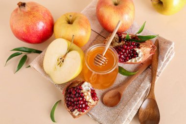 Bej arka planda Rosh Hashanah kutlaması (Yahudi Yeni Yılı) için bal, nar ve elma kavanozu