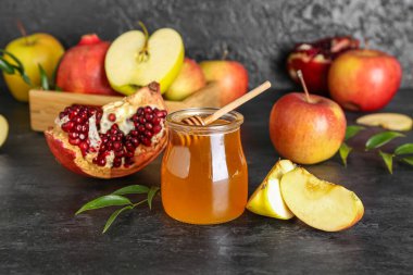 Rosh Hashanah kutlaması için kavanoz bal, nar ve elma (Yahudi Yeni Yılı) siyah masada