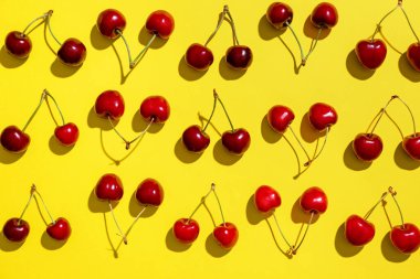 Sarı arka planda bir sürü tatlı kiraz