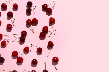 Pembe arka planda bir sürü tatlı kiraz