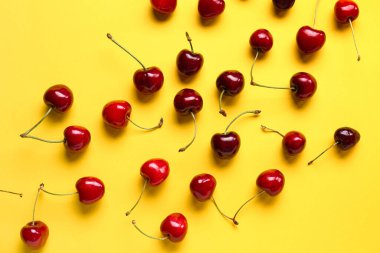 Sarı arka planda bir sürü tatlı kiraz