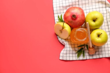 Kırmızı zemin üzerinde Rosh Hashanah kutlaması (Yahudi Yeni Yılı) için bal, nar ve elma kavanozu