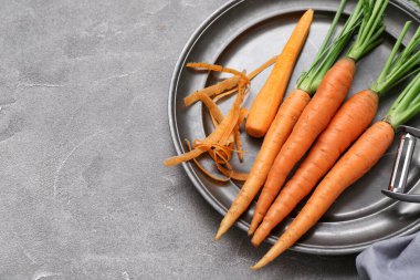 Gri desenli arka planda taze havuç tabağı